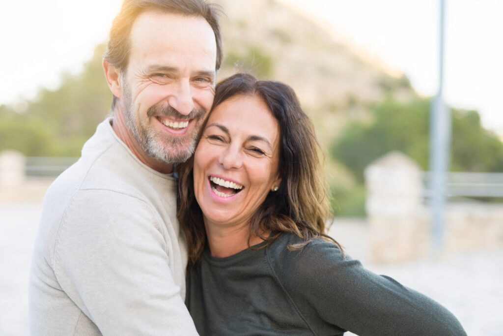 Romantic couple smiling and cuddling on a sunny day